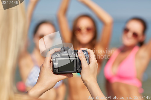 Image of close up of smiling women photographing on beach