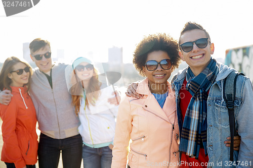 Image of happy teenage friends in shades talking on street