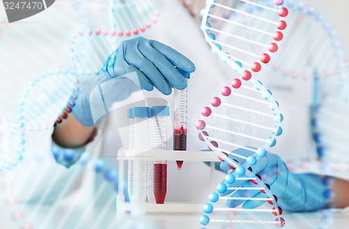 Image of close up of scientist with tube making test in lab