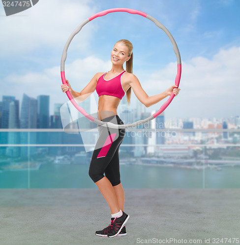 Image of young sporty woman with hula hoop