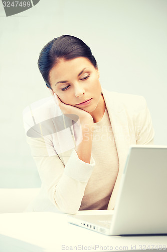 Image of pensive woman with laptop computer