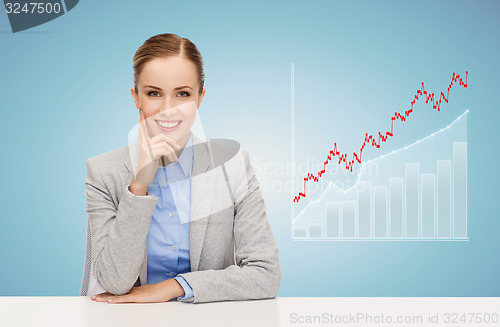 Image of smiling businesswoman sitting at table with chart