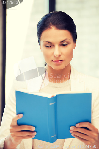 Image of calm and serious woman with book