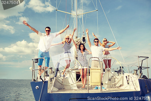 Image of smiling friends sitting on yacht deck and greeting