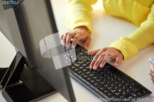 Image of close up of female hands with computer typing