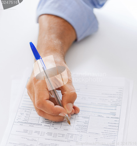 Image of man filling tax form