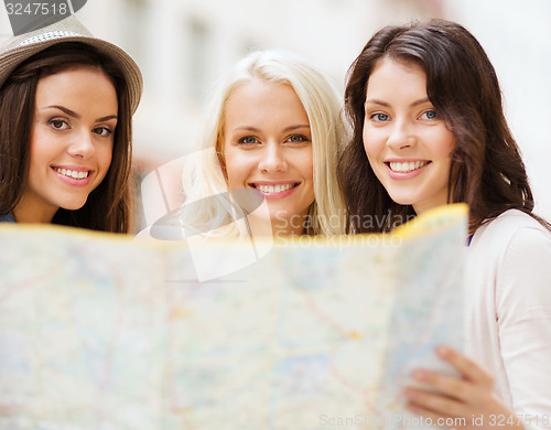Image of beautiful girls with map in the city