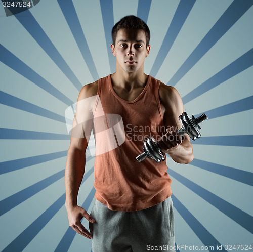 Image of young man with dumbbell flexing biceps