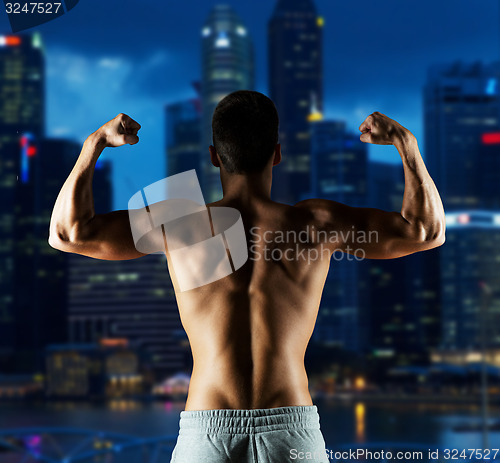 Image of young man or bodybuilder showing biceps