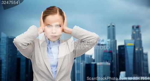 Image of stressed businesswoman with covered ears