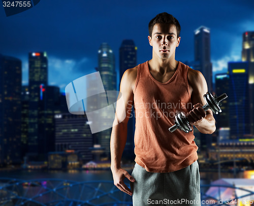 Image of young man with dumbbell flexing biceps