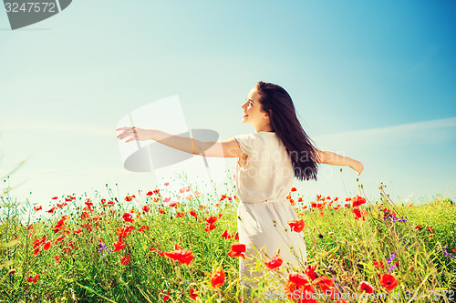 Image of smiling young woman on poppy field