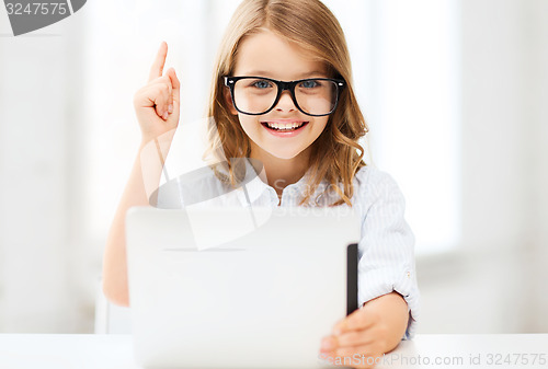 Image of smiling girl in glasses with tablet pc at school
