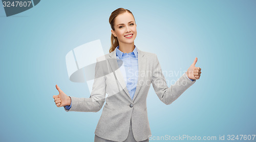 Image of smiling businesswoman showing thumbs up