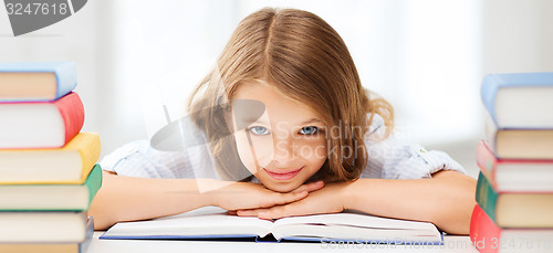 Image of pretty girl with many books at school