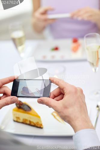 Image of close up of couple with smartphones at restaurant