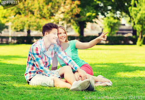 Image of smiling couple sitting on grass in park