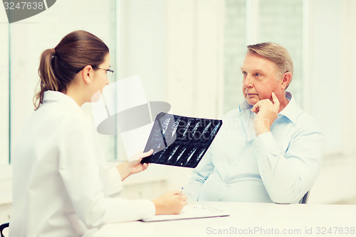 Image of female doctor with old man looking at x-ray