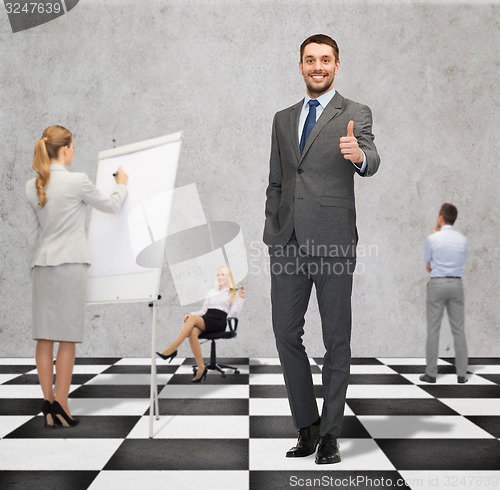 Image of happy businessman showing thumbs up gesture