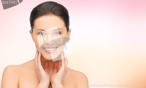 Image of beautiful young woman touching her face and neck