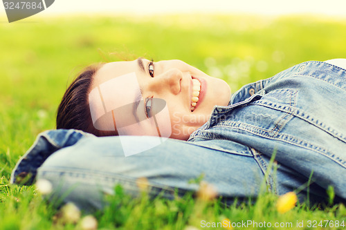 Image of smiling young girl lying on grass