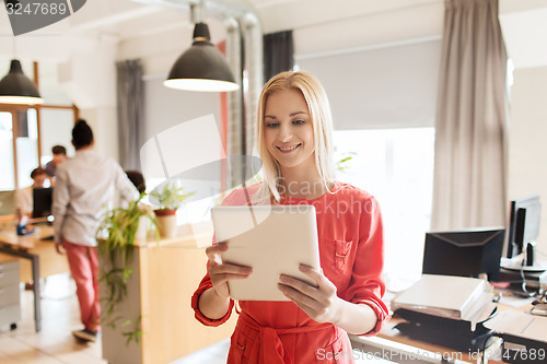 Image of happy creative female office worker with tablet pc