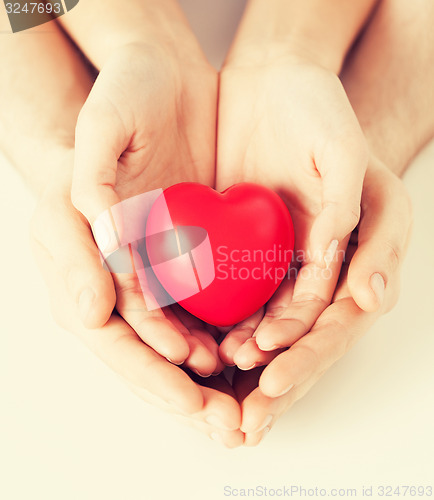 Image of woman and man hands with heart