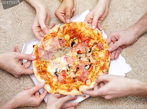 Image of close up of happy friends eating pizza at home