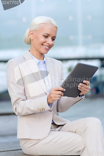 Image of smiling businesswoman with tablet pc outdoors