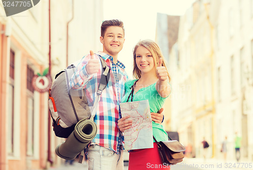 Image of smiling couple with map and backpack in city
