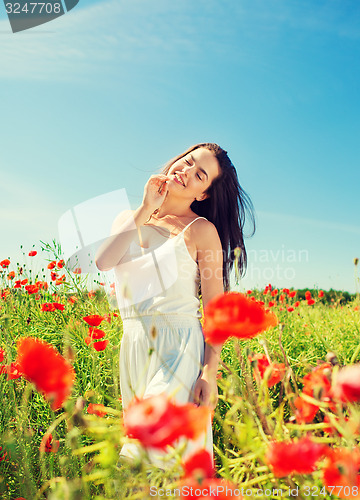 Image of smiling young woman on poppy field