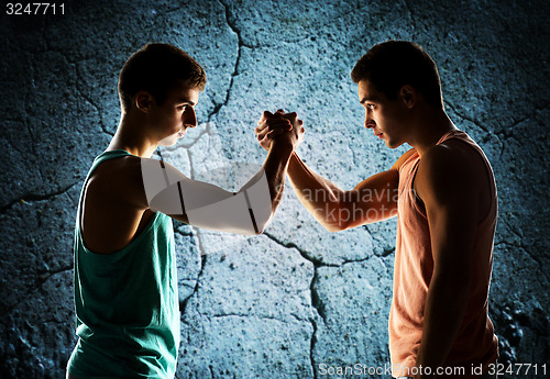 Image of two young men arm wrestling