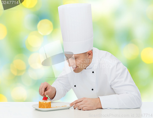 Image of happy male chef cook decorating dessert