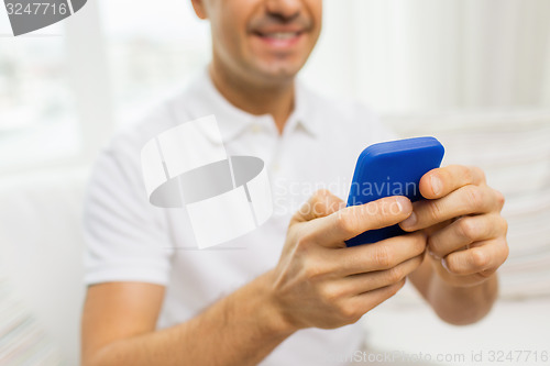 Image of close up of happy man with smartphone at home