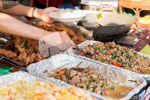 Image of close up of hands with wok at street market