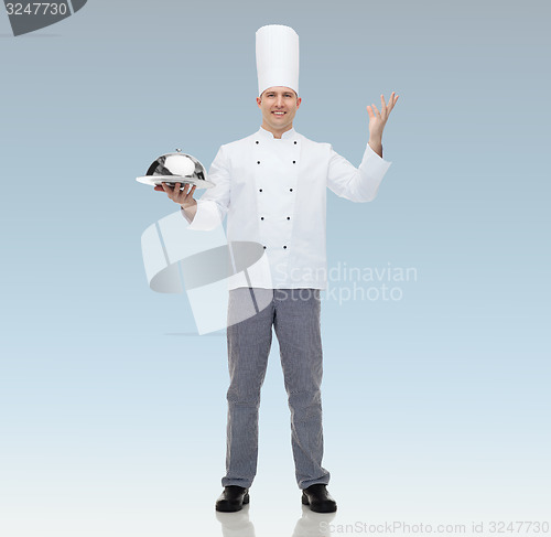 Image of happy male chef cook holding cloche