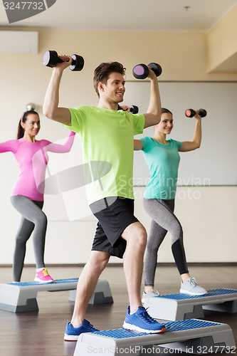 Image of group of people with dumbbells and steppers