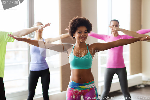 Image of group of smiling people dancing in gym or studio