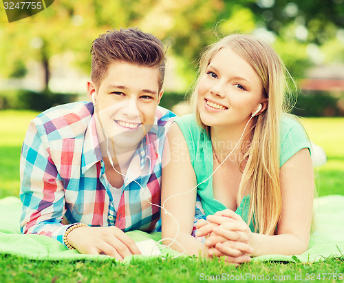 Image of smiling couple with smartphone and earphones