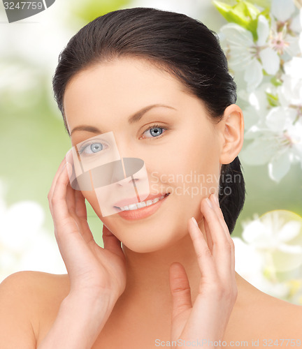 Image of beautiful young woman touching her face