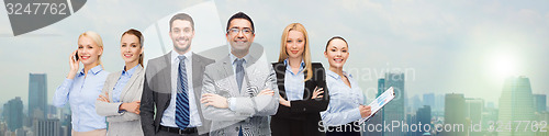 Image of group of smiling businessmen over city background