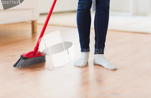 Image of close up of woman legs with broom sweeping floor