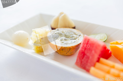 Image of plate of fresh juicy fruit dessert at restaurant