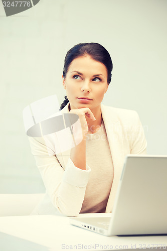 Image of pensive woman with laptop computer