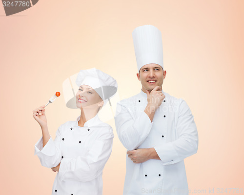 Image of happy chefs or cooks couple over beige background