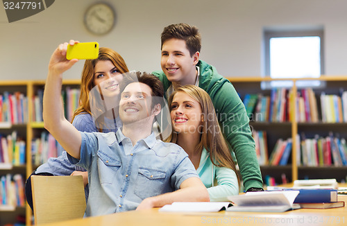 Image of students with smartphone taking selfie in library