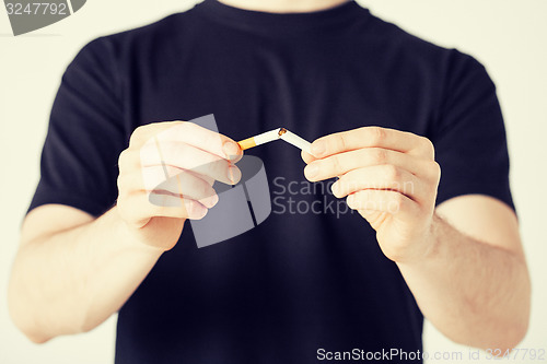 Image of man breaking the cigarette with hands
