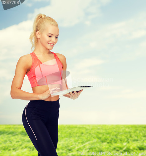 Image of smiling sporty woman with tablet pc computer