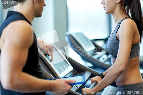 Image of close up of woman with trainer on treadmill in gym