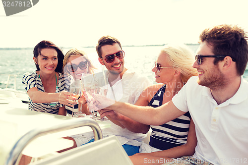 Image of smiling friends with glasses of champagne on yacht